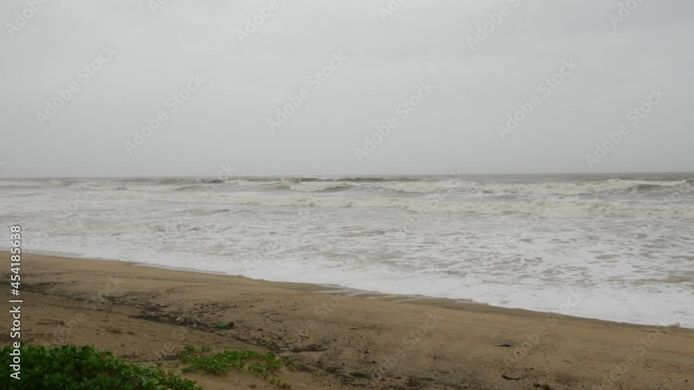 View of sea waves containing white foam striking sea shore View of sea waves containing white foam striking sea shore