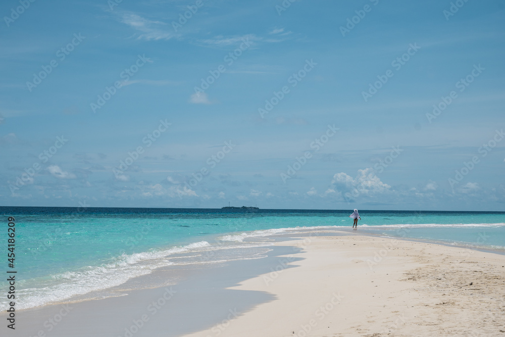 Tropical nature. A happy and free girl walks near the ocean on a beach with white sand. Travel and recreation. Tropical nature. A happy and free girl walks near the ocean on a beach with white sand. Travel and recreation.