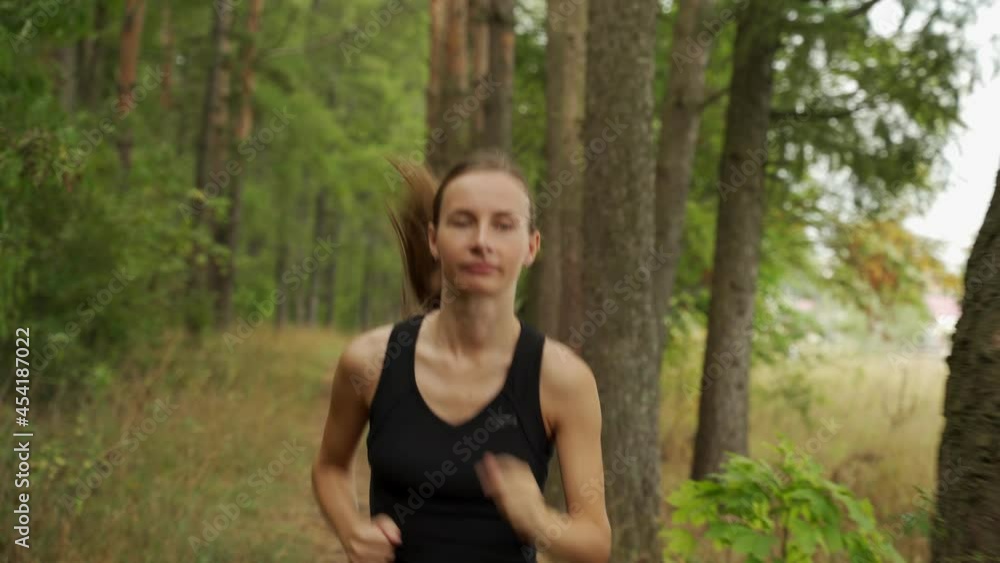 Beautiful woman runs around the park. Athletic young beautiful woman jogging through the forest. Beautiful woman runs around the park. Athletic young beautiful woman jogging through the forest.