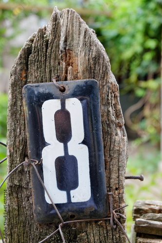 number eight hanging on a board from an old wooden fence with wire