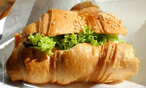 half a croissant topped with sesame seeds full of green cabbage close-up
