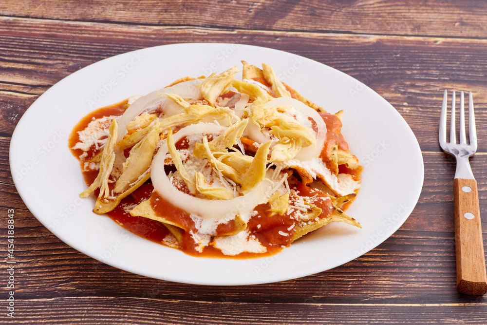 Fototapeta premium Chilaquiles rojos con pollo, comida tradicional mexicana en el desayuno o comida