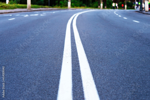 The asphalted road with  white strips. The highway with a white marking. Concept long way  beginning something