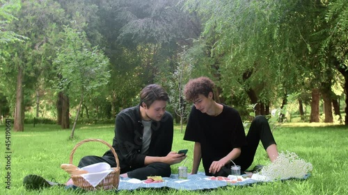 Two young guys looking at the phone in nature in the summer