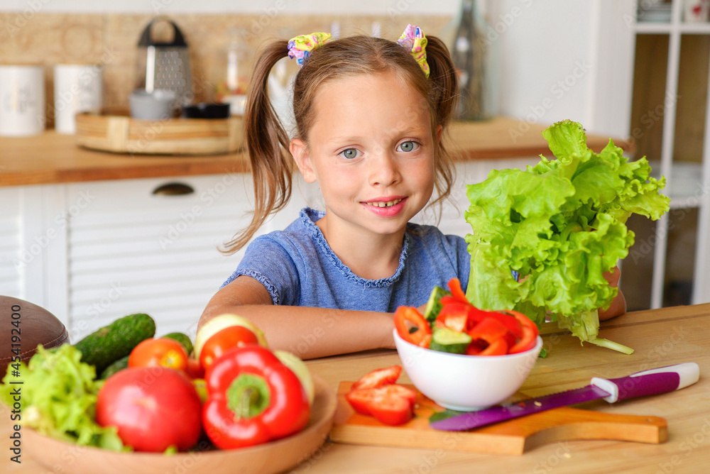 Adorable child is cooking in the kitchen. Pretty pretty girl prepares soup. Little chef preparing healthy food vegetable salad Adorable child is cooking in the kitchen. Pretty pretty girl prepares soup. Little chef preparing healthy food vegetable salad
