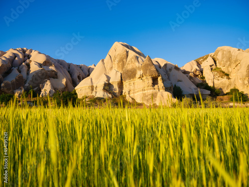 A field and a high mountain during sunset. Lines of mountains and rocks again...