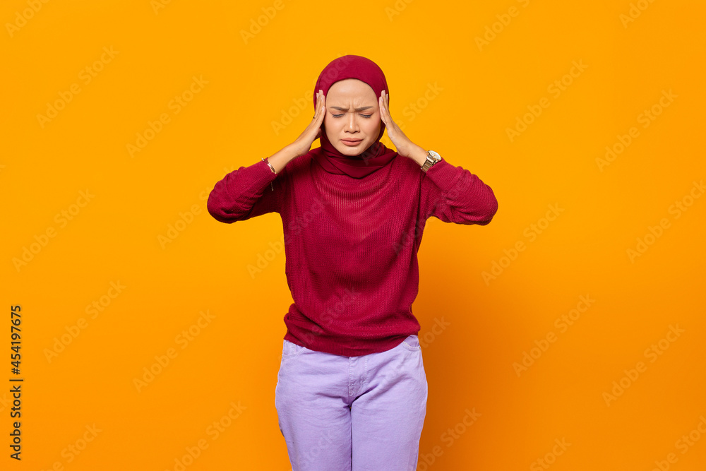 Fototapeta premium Beautiful Asian woman holding her temples, having a headache, with her eyes closed