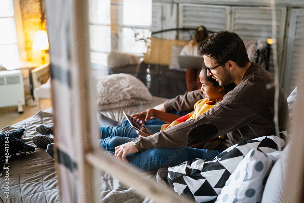 Happy multiethnic single parent studying with child at home Happy multiethnic single parent studying with child at home