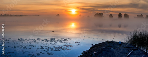 Colorful landscape with golden misty morning on a river or lake, fishing faci...