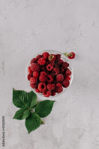 Fresh raspberry in glass vase flatlay