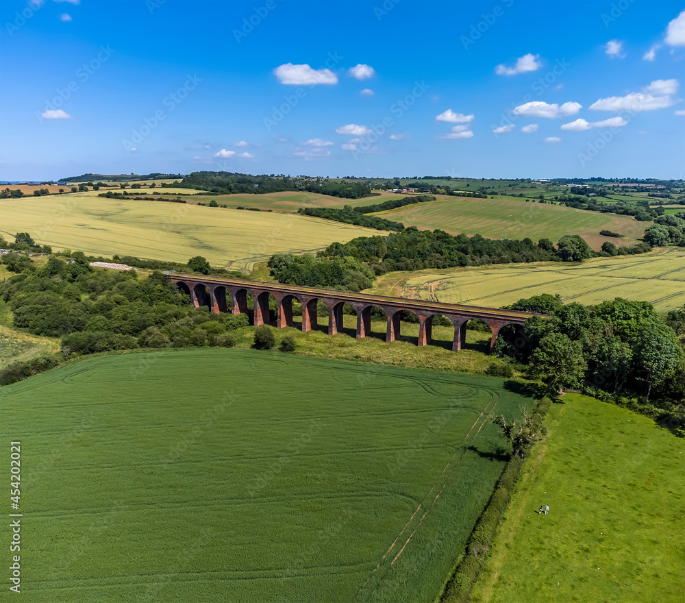 An aerial view along the Victorian railway viaduct at John O'Gaunt valley, Leicestershire, UK in summertime