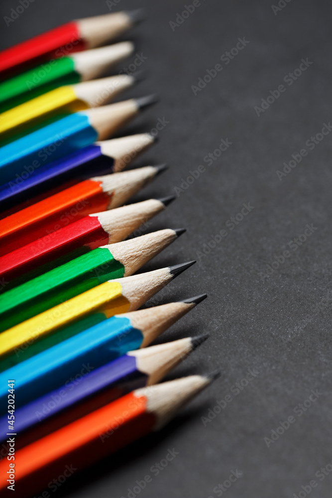 Colored pencils in a row on a black background Colored pencils in a row on a black background