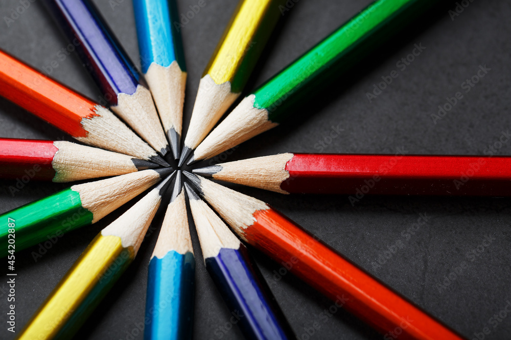 Multicolored pencils in the shape of a star on a black background. Multicolored pencils in the shape of a star on a black background.
