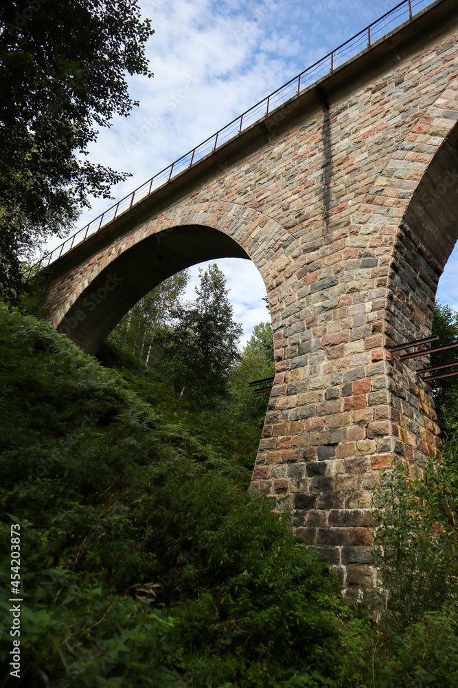old abandoned stone railway arch bridge over the river in the forest old abandoned stone railway arch bridge over the river in the forest