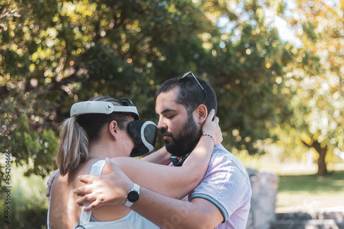 a fat couple tried virtual reality glasses in a park. photo