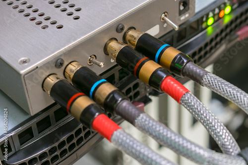 The AV cables are connected to a digital amplifier. The digital signal converter is in the rack. The multimedia equipment works in the server room. photo