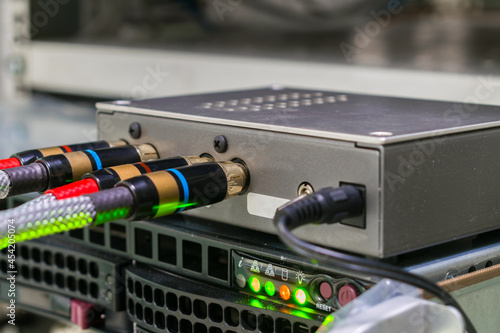 The AV cables are connected to a digital amplifier. The digital signal converter is in the rack. The multimedia equipment works in the server room. photo