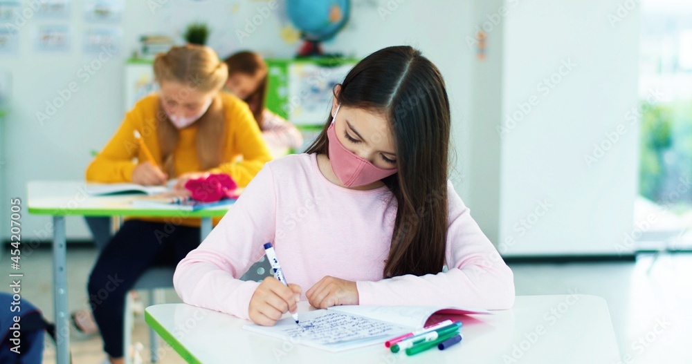 Close up of multi-ethnic diverse school children sitting in classroom writing in copybook with pencil, studying, education learning concept Male and female junior students sitting at desk in classroom Close up of multi-ethnic diverse school children sitting in classroom writing in copybook with pencil, studying, education learning concept Male and female junior students sitting at desk in classroom