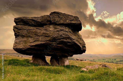 Dramatic cloudy sky frames a single perched erratic, part of the Norber erratics, near Settle in the Yorkshire Dales