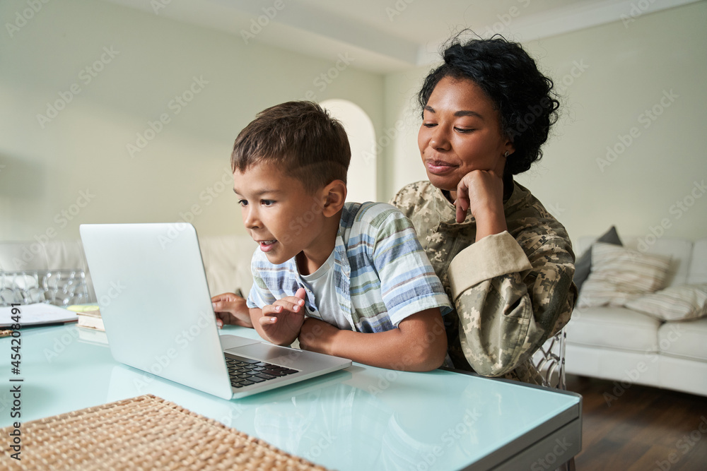 Black mother and son watching something on laptop Black mother and son watching something on laptop