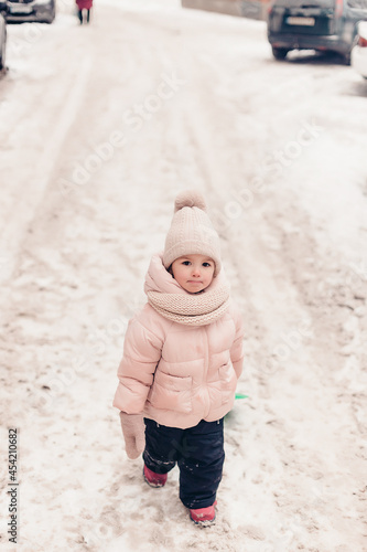 portrait of a tired or upset little girl asking her parents for a winter walk