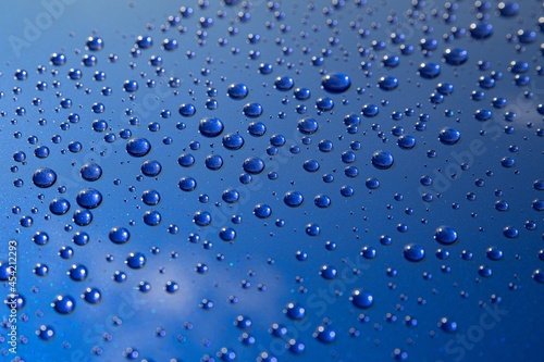 Fotografia Water drops on car paint. Hydrophobic water effect on car body.