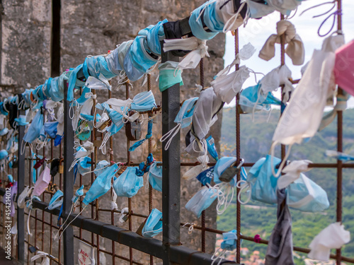 Used masks tied to a fence. New travel traditions during Covid-19. photo