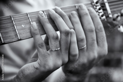 noivos tocando o violão com aliança no dedo photo