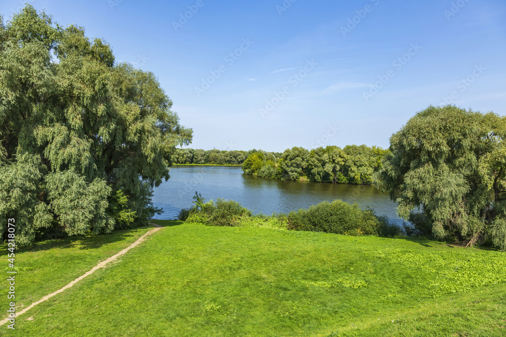 River landscape with bright green trees on a sunny summer day River landscape with bright green trees on a sunny summer day