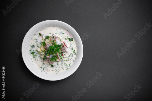 close up of russian traditional cold soup okroshka in bowl on black background