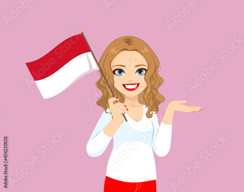Beautiful blonde curly hair Monegasque woman holding Monaco flag making showing hand gesture 