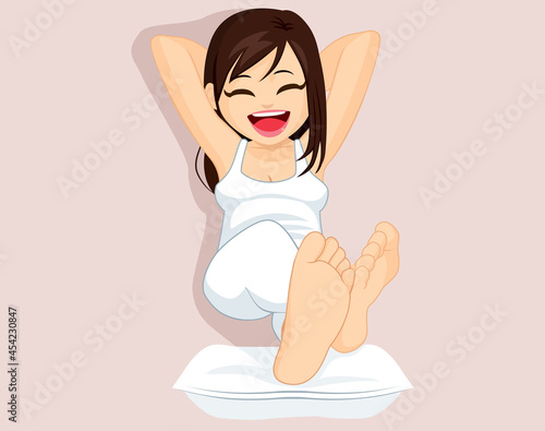 Young brunette happy relaxed woman wearing white comfy pajamas resting barefoot feet on pillow