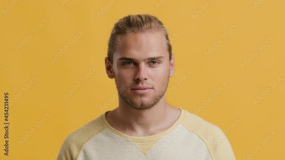 Closeup Portrait Of Handsome Young Blonde Guy Posing Over Yellow Studio Background Closeup Portrait Of Handsome Young Blonde Guy Posing Over Yellow Studio Background