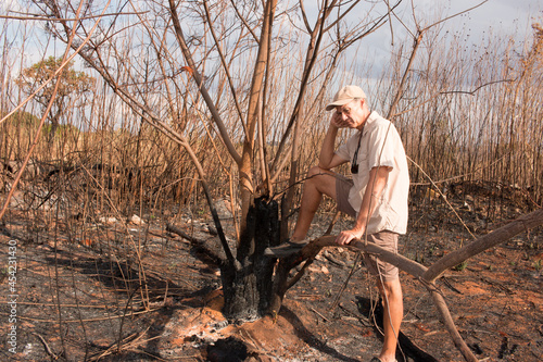 Man from the environment inspecting the remains of a brush fire at an illegal trash dump in Granja do Torto, north of Brasilia, Brazil photo