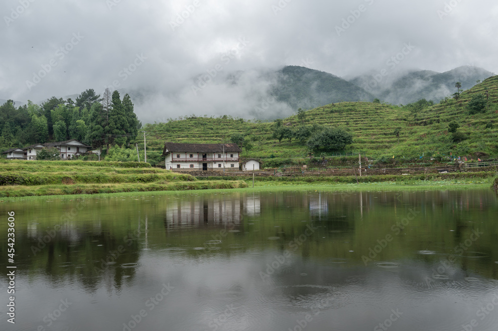 The lake reflected the mountain with houses and fog on the mountain The lake reflected the mountain with houses and fog on the mountain