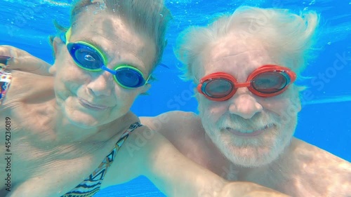 Wallpaper Mural Couple of two happy seniors having fun and enjoying together in the swimming pool smiling and playing. Happy people enjoying summer outdoor in the water
 Torontodigital.ca