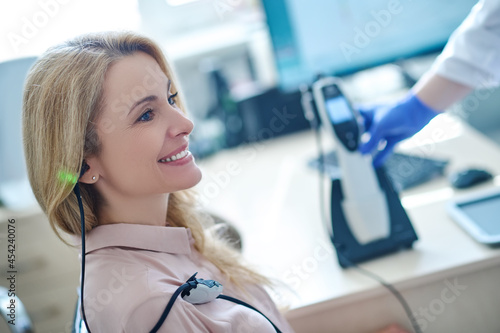 Foto Middle-aged female patient being tested for auditory acuit