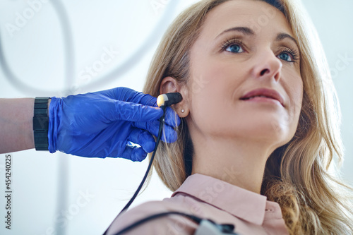 Tranquil patient undergoing an audiometry test performed by an audiologist photo