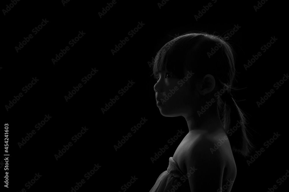 A cute adorable Asian girl about 6years old poses for a photo in the black and white background. A cute adorable Asian girl about 6years old poses for a photo in the black and white background.