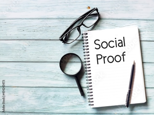 Foto Social proof text with notebook, a pen, magnifying glass and eye glasses