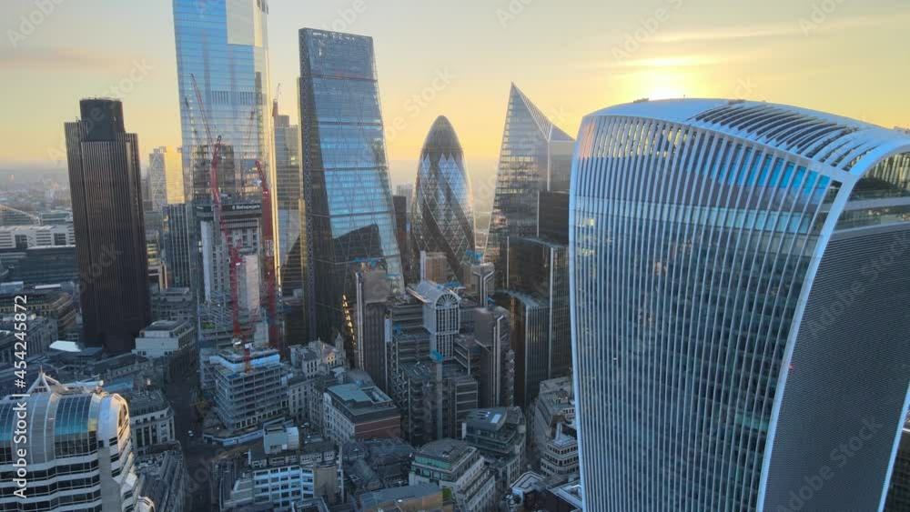 tall modern buildings against golden sunrise sky. Skyscrapers in City financial and economy centre. London, UK