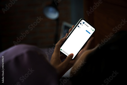 women using phone texting social on bed at night