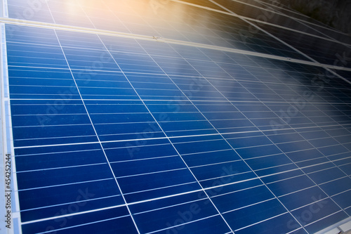 Photovoltaic roof with reflection of the Sun and clouds on the surface.