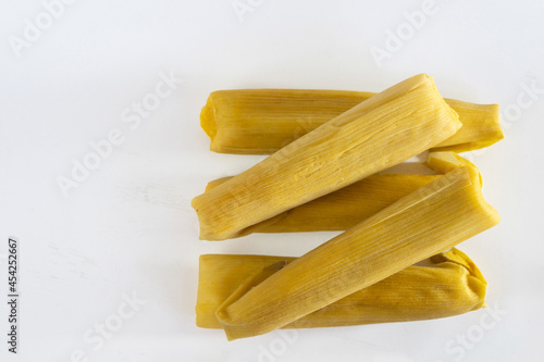 Traditional Andean food, corn humitas on white background. Copy space. photo