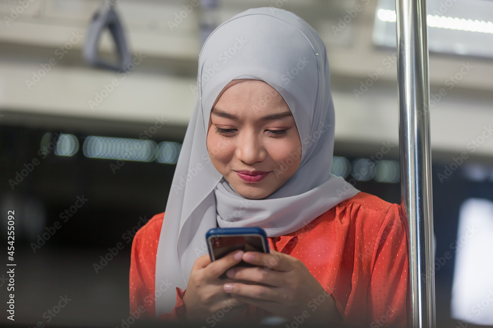 Asian muslim woman wear hijab head scarf and using mobile phone in the ...
