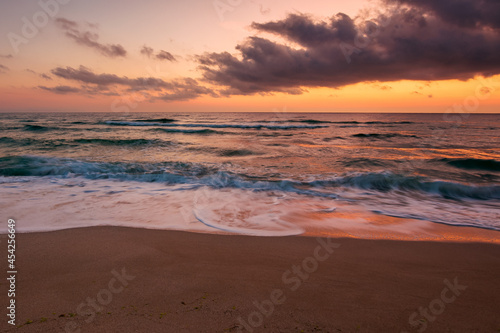 Fototapeta Naklejka Na Ścianę i Meble -  calm sea scenery at dawn. waves wash empty sandy beach at twilight. relax and summer vacation concept. warm velvet season weather with clouds on the sky