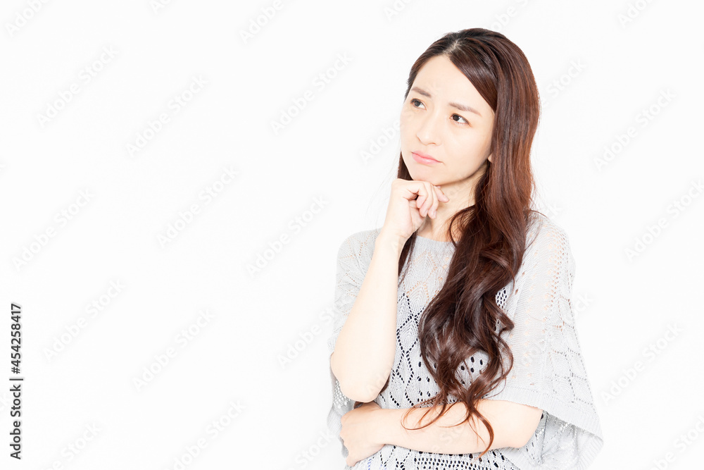 悩み事を抱えて困っているカジュアルな服装の女性 悩み事を抱えて困っているカジュアルな服装の女性