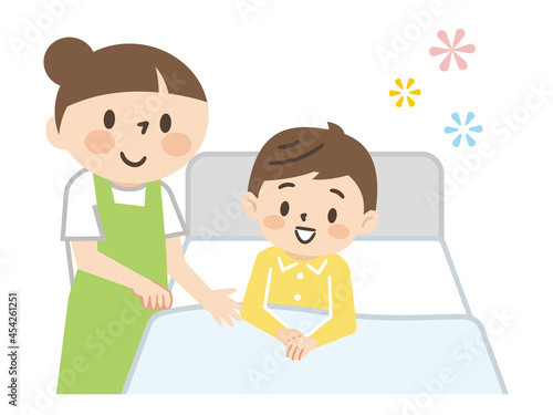 ベッドに横たわる男の子と介護する女性の介護士
