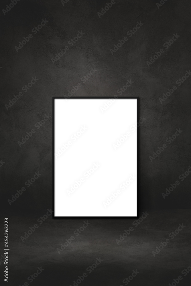 Blank picture frame leaning on a black wall Blank picture frame leaning on a black wall