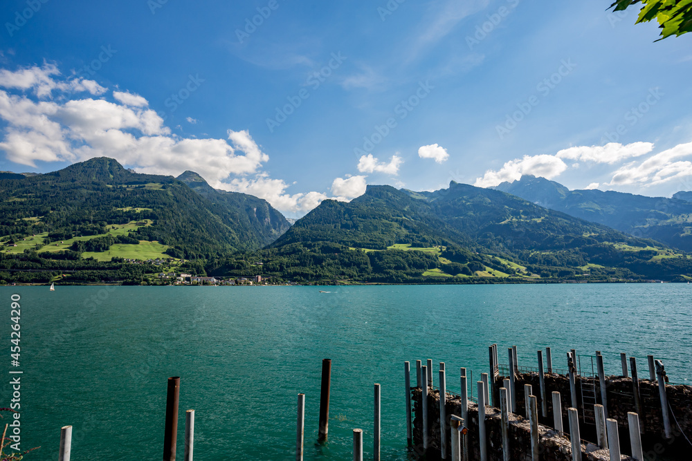 Wooden poles at the small port of Quentin at lake Walensee in the Swiss Alps. Sunny spring day with outdoor activities in Switzerland